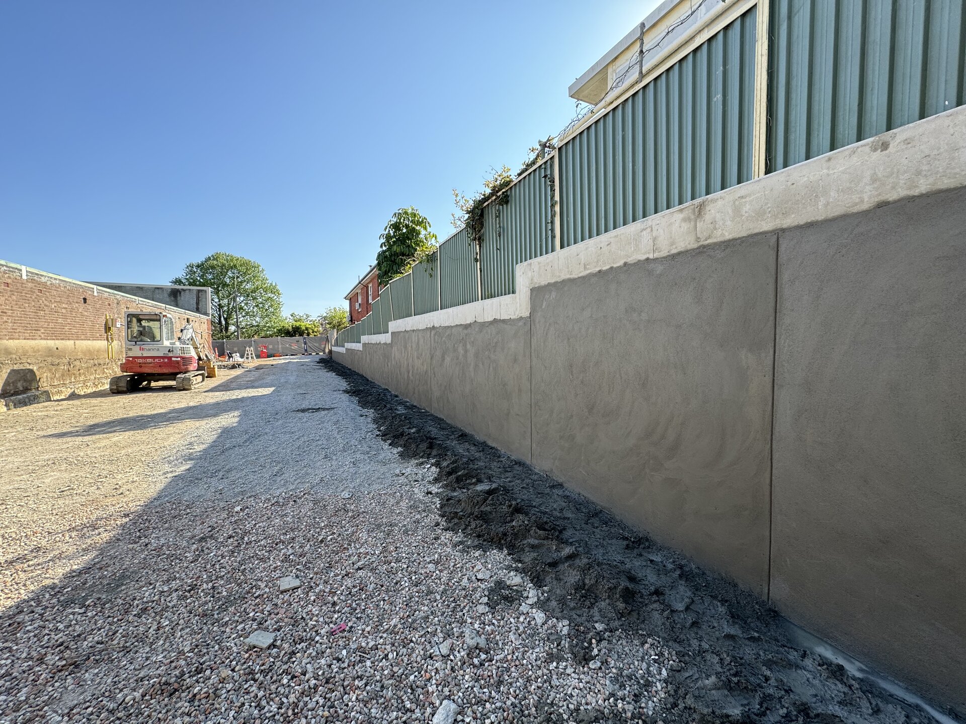 Completed rendered boundary retention wall on a shoring job, Roselands NSW